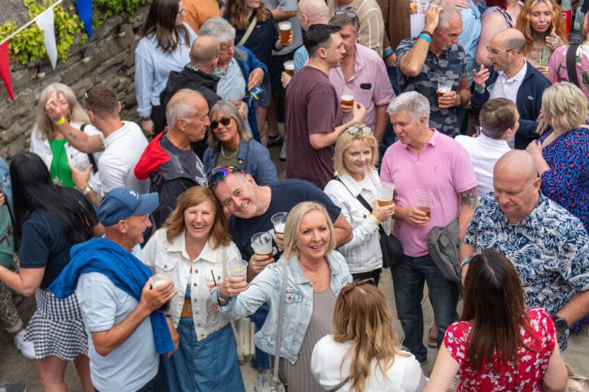 People drinking and chatting at a beer festival. 