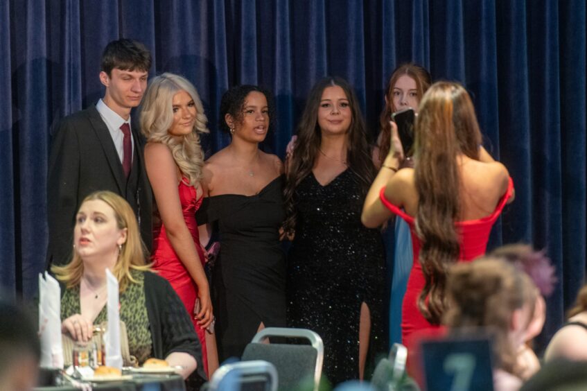 A group is photographed by another attendee