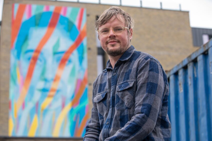 Fraser Gray in front of striking mural