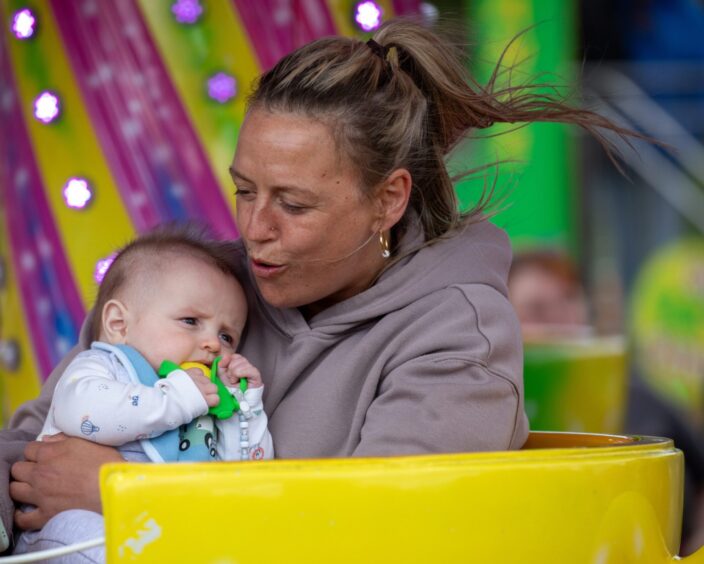 A woman and baby on a funfair ride