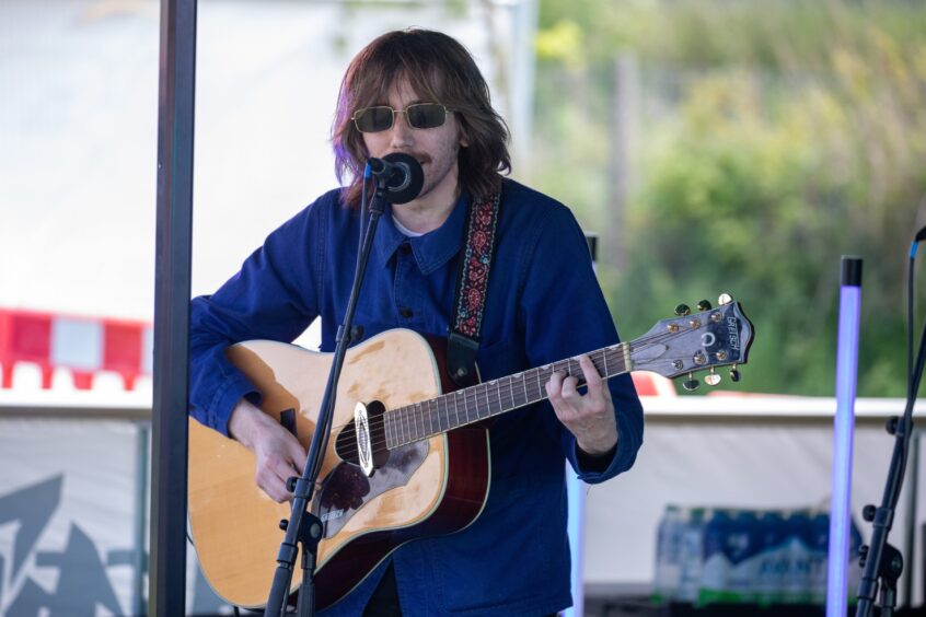 Marcel and St John plays a guitar on the Westfest stage
