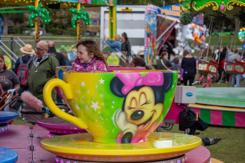 A young girl on a teacup ride