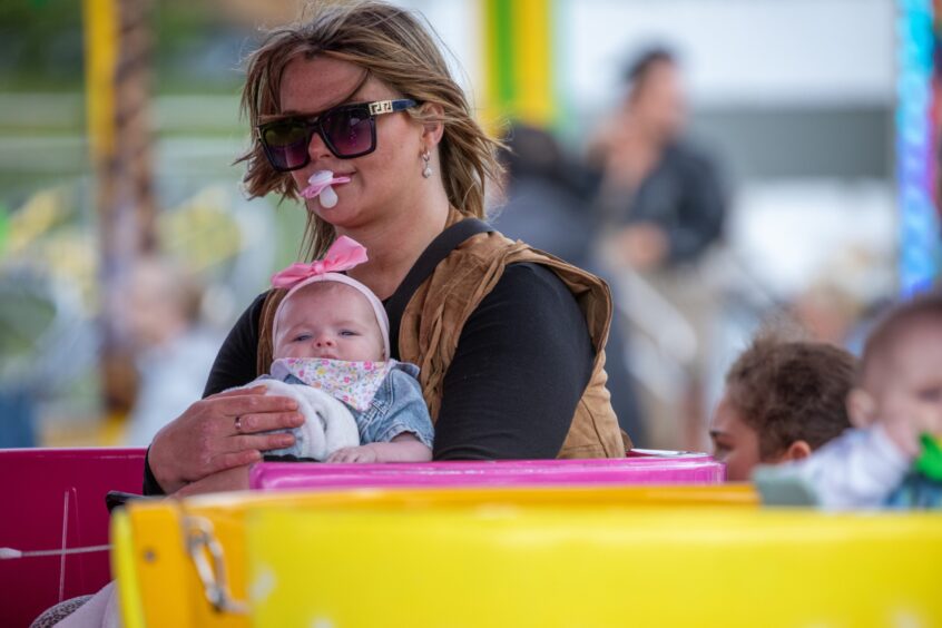 A woman and baby on a funfair ride.