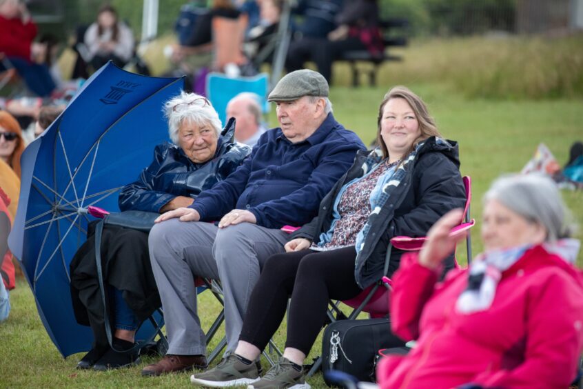 People sitting outside with an umbrella