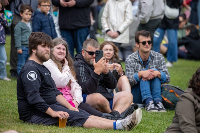 People sit on the grass and listen to music