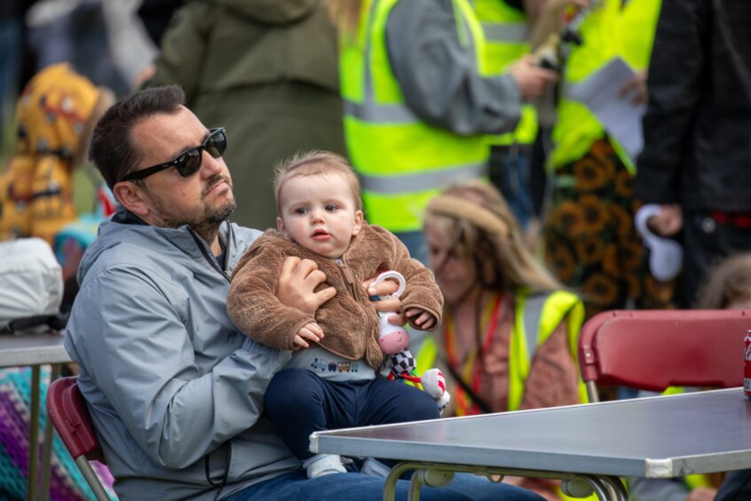 A man and baby listen to the music.