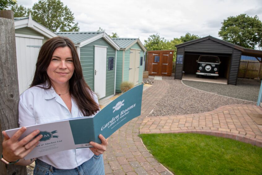 Cara outside wit Gillies and Mackay brochure