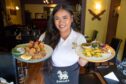 Nongmay Buncharoen in Mae PingThai Dining holding two plates of food