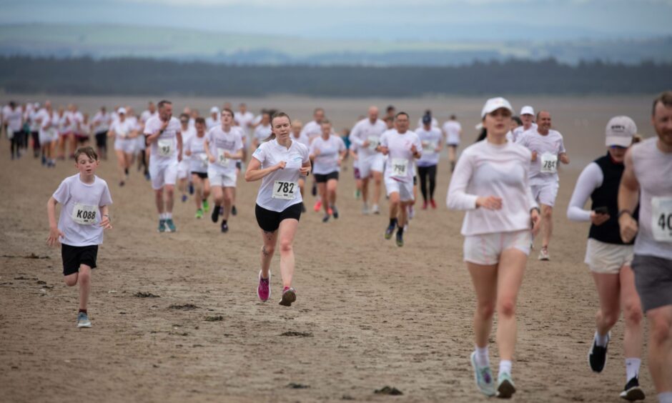Braving the rain showers, Chariots of Fire beach race runners in St Andrews