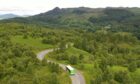 Trossachs Explorer bus in countryside.
