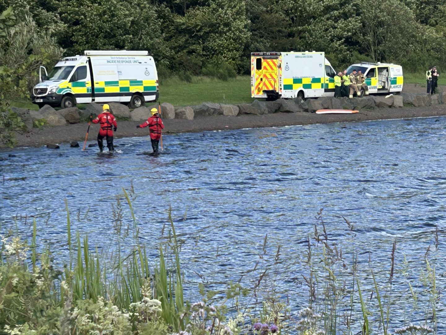 Officers searching the shallow water.
