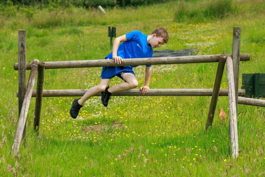 A boy makes light work of a hurdle-type obstacle.
