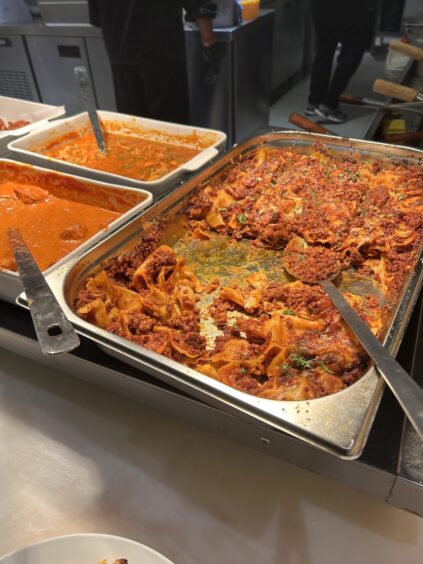 A tray of lasagne sitting on a counter at Booffi World Buffet.