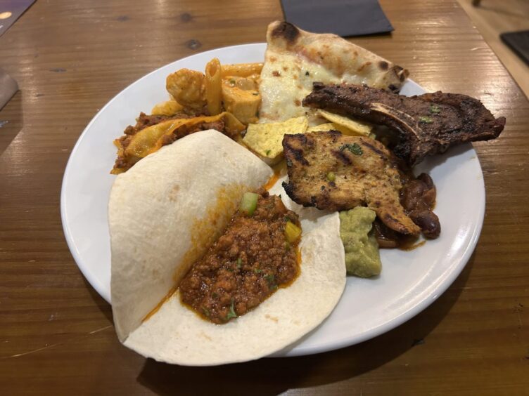 A plate full of Mexican and Italian food.