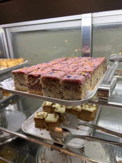 A selection of cakes sitting in a fridge.