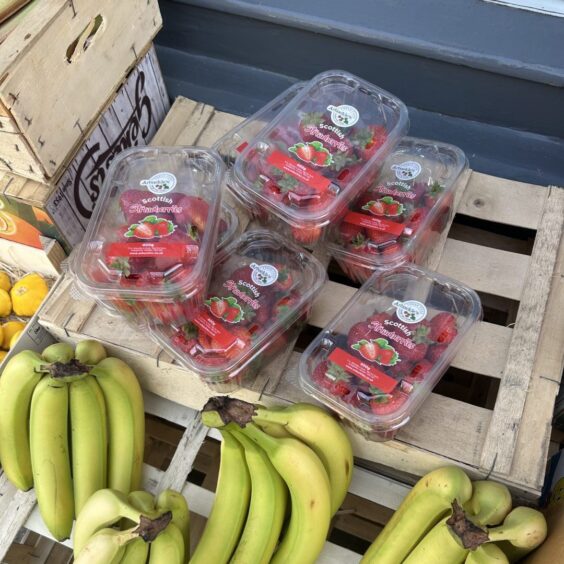 Punnets of strawberries and bunches of bananas outside Clementine.