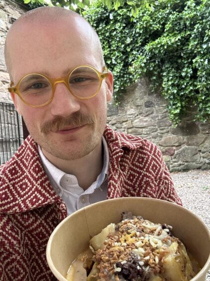 Jacob Smith holding up a baked potato.