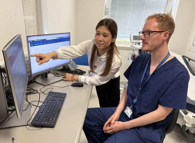 Dr Jonathan Begley and Dr Ingin Phyu Phyu study data on a computer screen. 