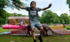 Runners tackling an obstacle during Pretty Muddy, a 5k mud-splattered obstacle course at Race for Life Dundee at Camperdown Park.