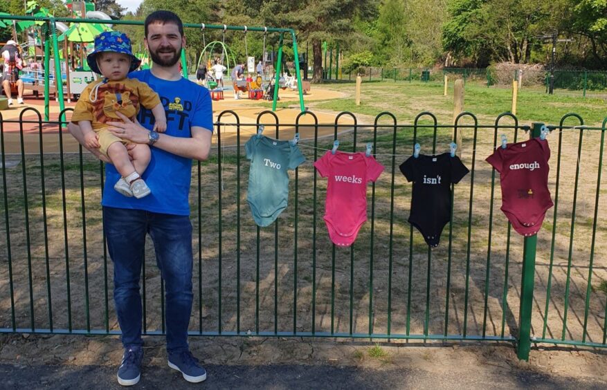 Ryan Connolly, with baby Lewis, hung babygros in the park to highlight the paternity leave campaign