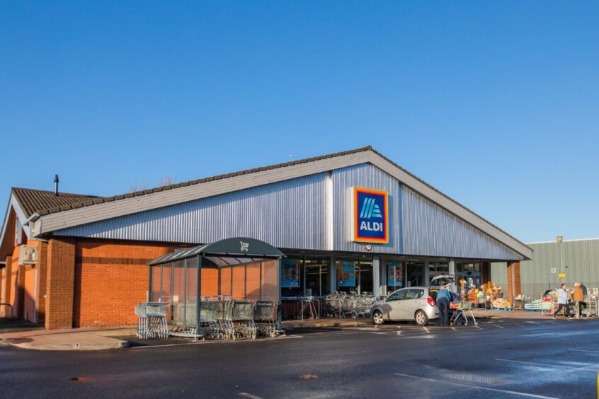 Aldi store exterior with supermarket trolleys and car park outside