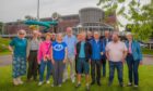 Small group of people standing on grass in front of Perth Leisure Pool