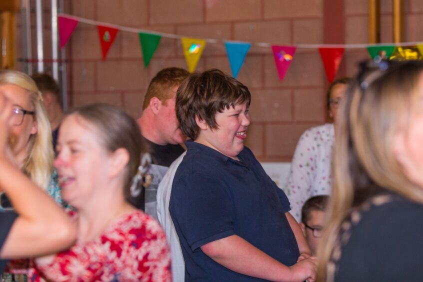 A boy laughing as a party is in full swing. 