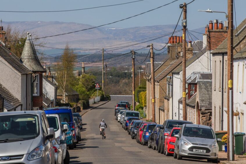 A view down the street in Dunning, with hills in the background. 