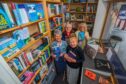 Group of people with books surrounded by shelves inside Pitlochry Station Bookshop