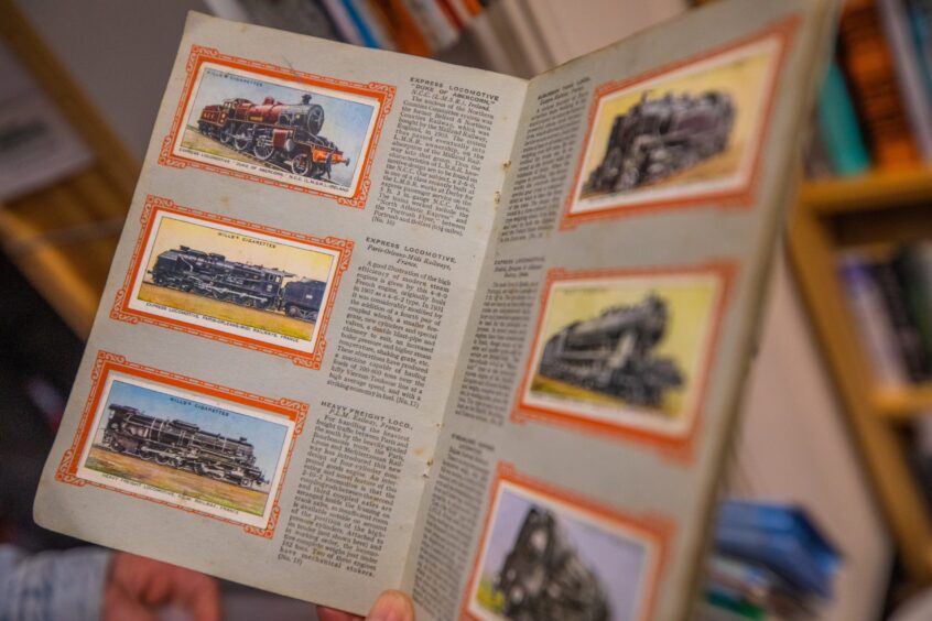 Close up of old book with cigarette cards stuck inside