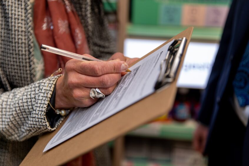 Gayle fills out a questionnaire at Boots.