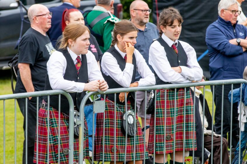 Three girls from George Watson's College watch other competitors.
