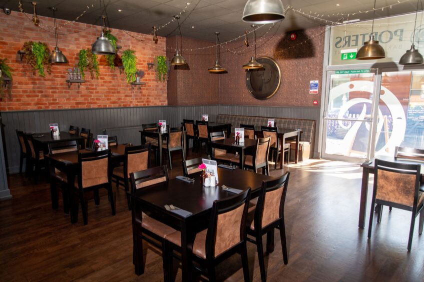 Inside Porters the space is bright and airy with dark wooden tables and fake plats adorn the red brick walls.