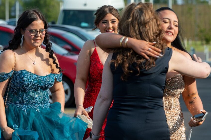 Two girls embrace as they arrive for the prom
