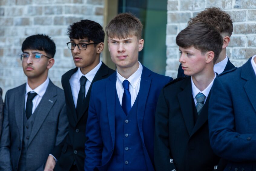 A group of boys wearing suits