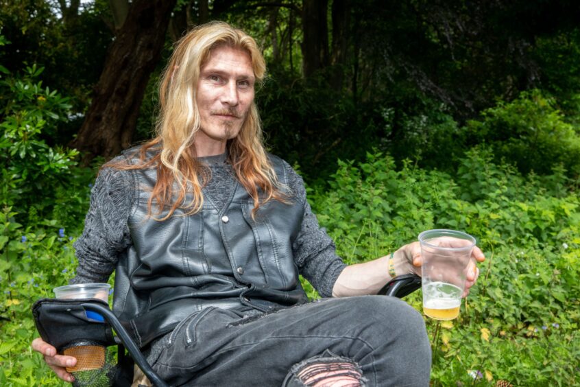 Damian Chalmers from Kirkcaldy sits in a camping chair with a drink in hand.