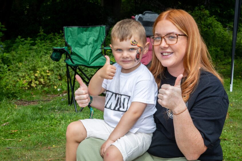Ashley Learmonth and Leland Strachan give thumbs up. Leland has a spider painted on his left cheek. 
