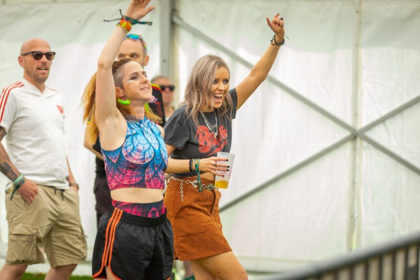 Revellers raise their hands in the air as they enjoy the music.