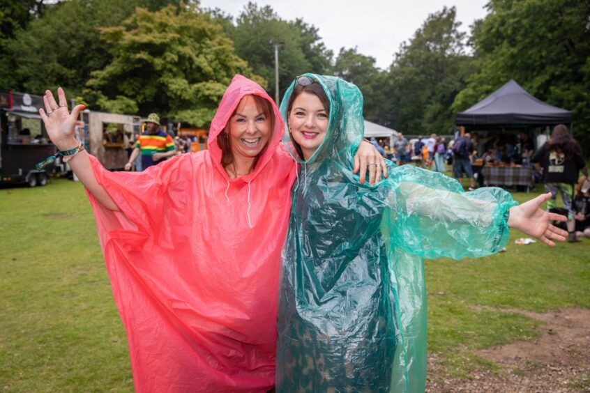 Nicola Dempsey and Rachelle Paige pose in their colourful rain ponchos.