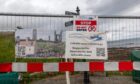 A notice attached to a fence warns of ongoing St Andrews harbour repair works