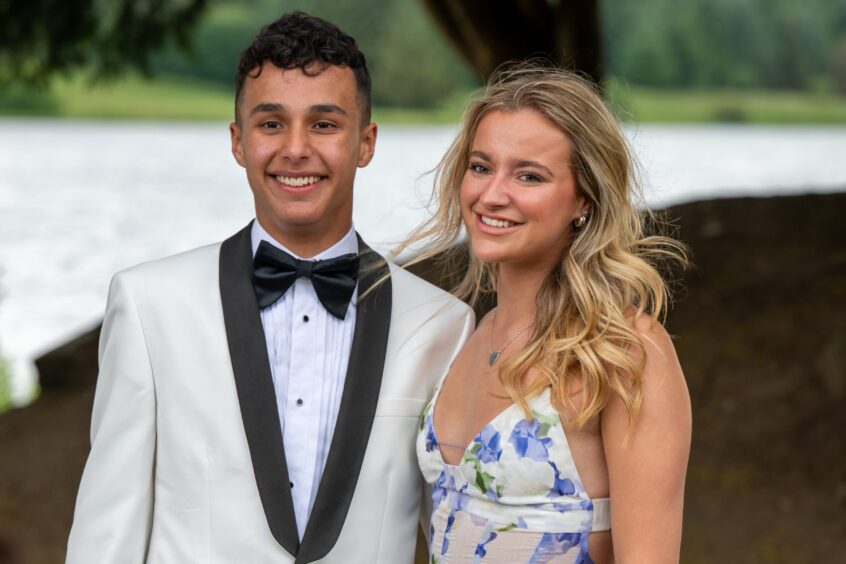 A smartly dressed boy and girl pose with the loch in soft focus behind them. 