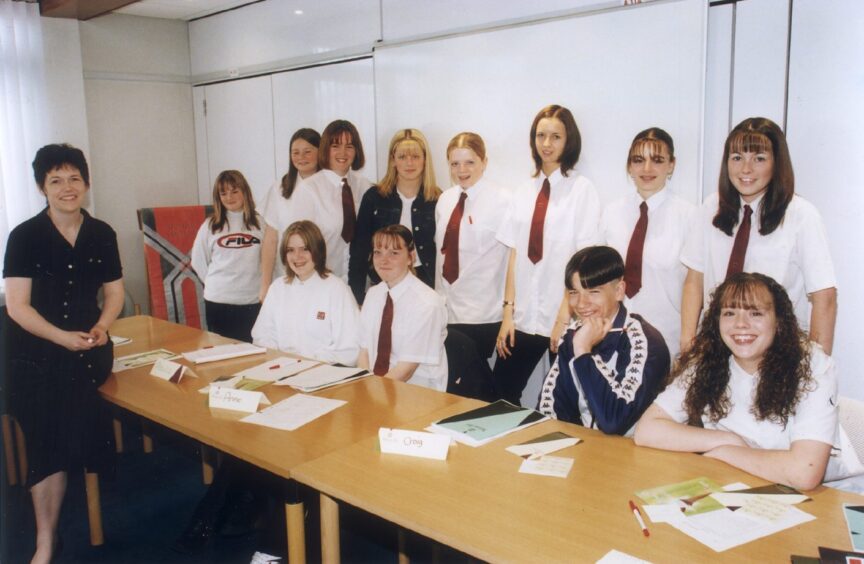 Karen Donaldson seated with pupils at table.