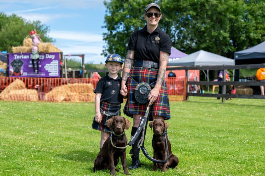 Hazel and Hamish chocolate Labrador puppies with owners Carol and Ross Johnson from Celtic KC Labradors.