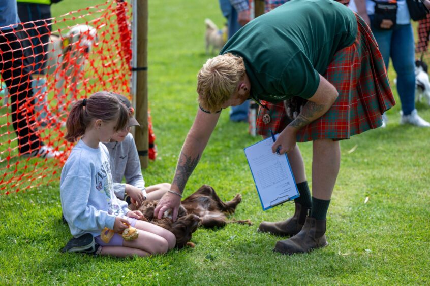 Allan Bruce of Pathhead Farm judges Skye during the prettiest dog contest as owners Ollie and Ellie watch. 