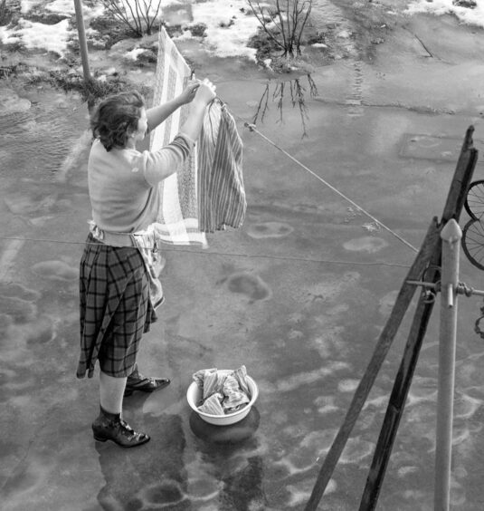 an elevated shot of a woman hanging out her washing in Perth. 