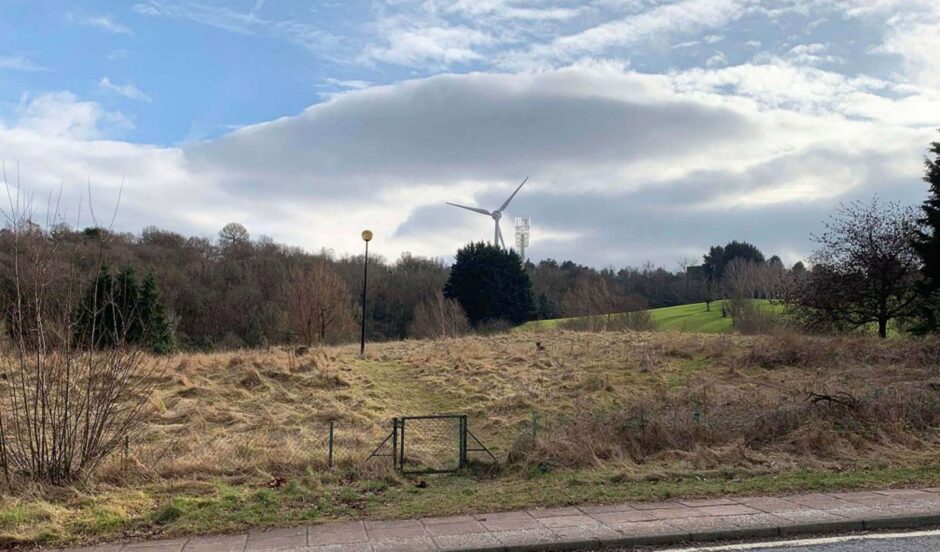 Artist's impression of the EE mast rising from an area of grassland with the existing turbine in the background. 