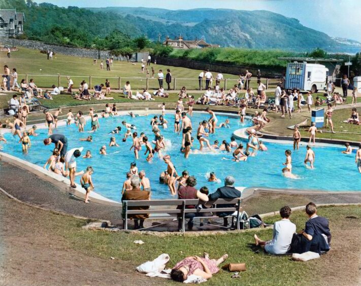 People sunbathe around an outdoor pool on a hot summer day in Burntisland in 1970.