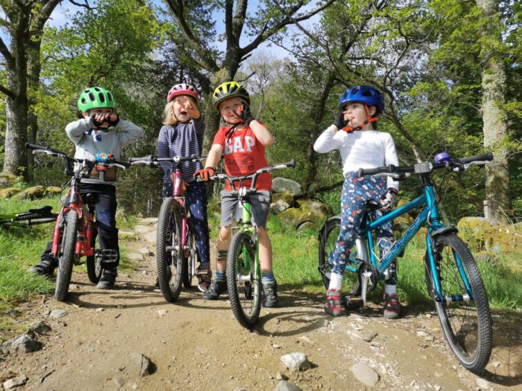 Children cycling on a woodland path. 