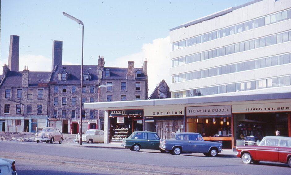 cars parked outside a parade of shops including The Grill and Griddle in Marketgait