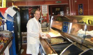 Frank Vella serving up the chips at The Victor in Blackness Road. Image: DC Thomson.